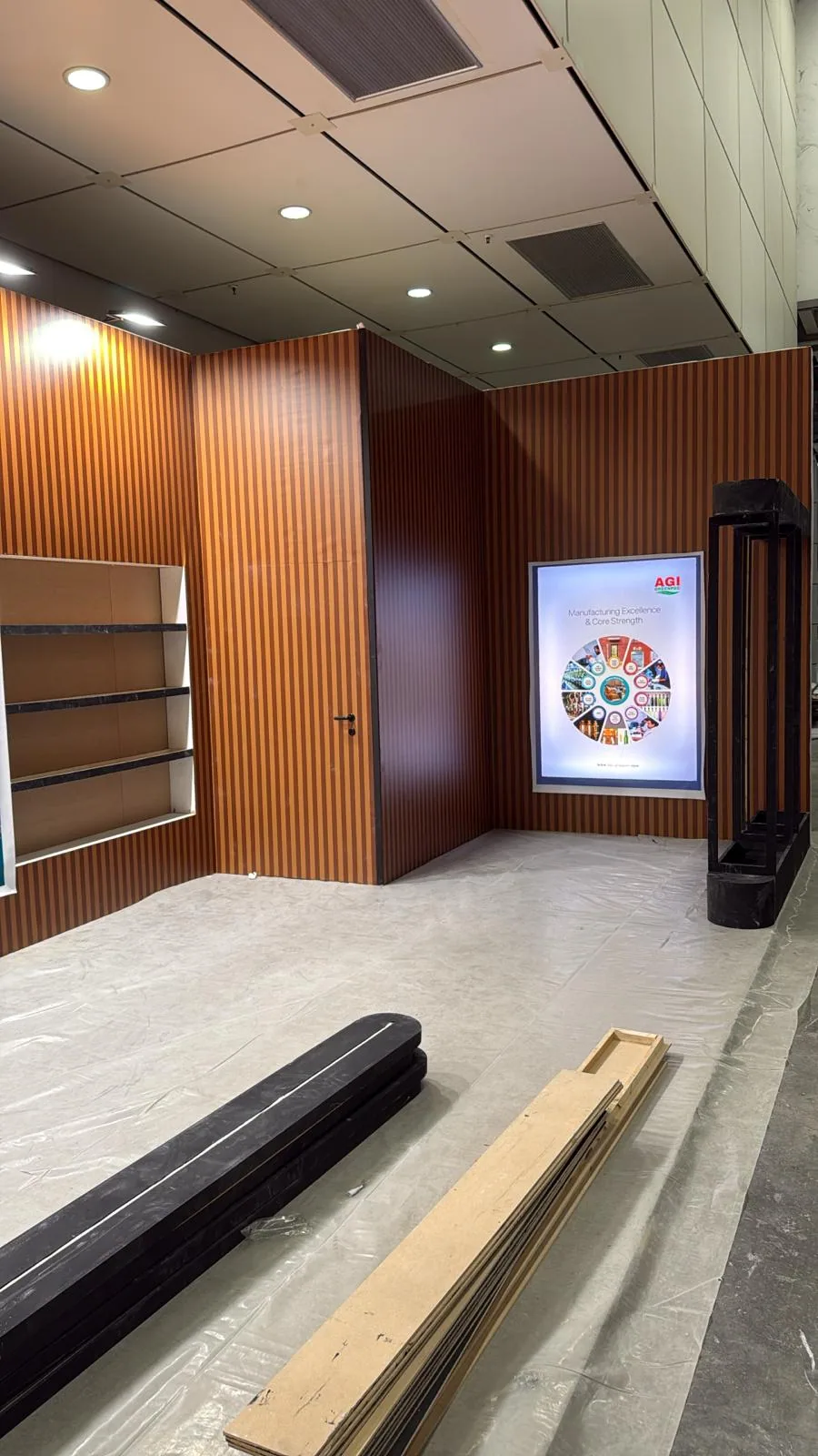 AGI Greenpac stand build showing illuminated display wall at Cosmoprof Worldwide Bologna, Bologna Fiere — installation by Echo Expo