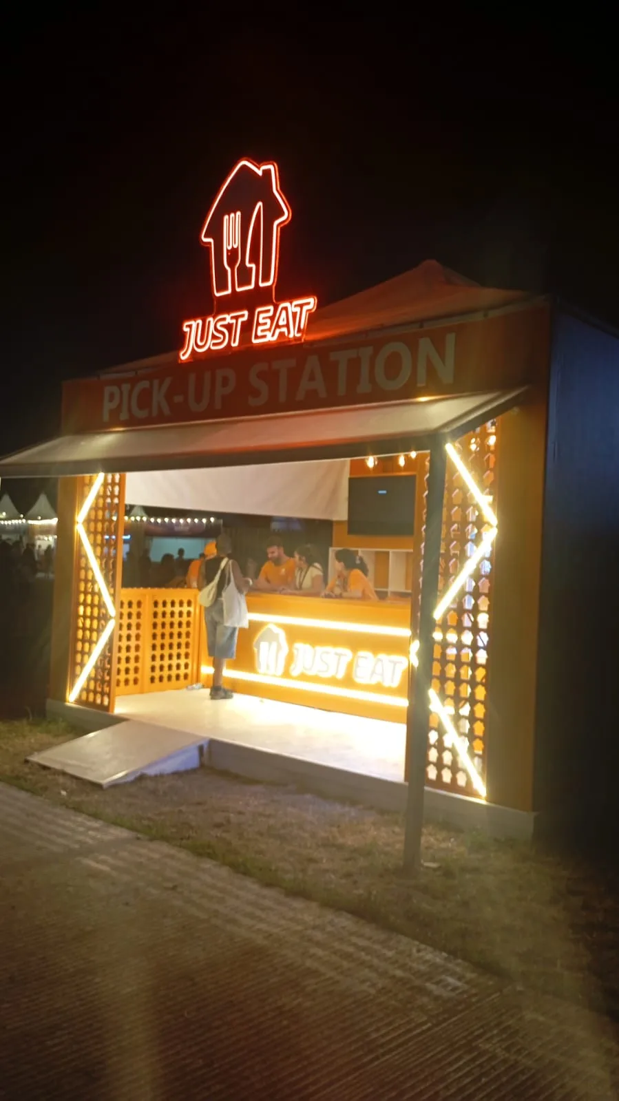 Just Eat pick-up station lit at night at Zurich Openair, Switzerland
