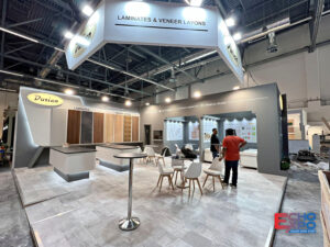 Durian Laminates exhibition stand at interzum Cologne 2025, with a suspended oval halo sign, laminate sample walls and open meeting seating.