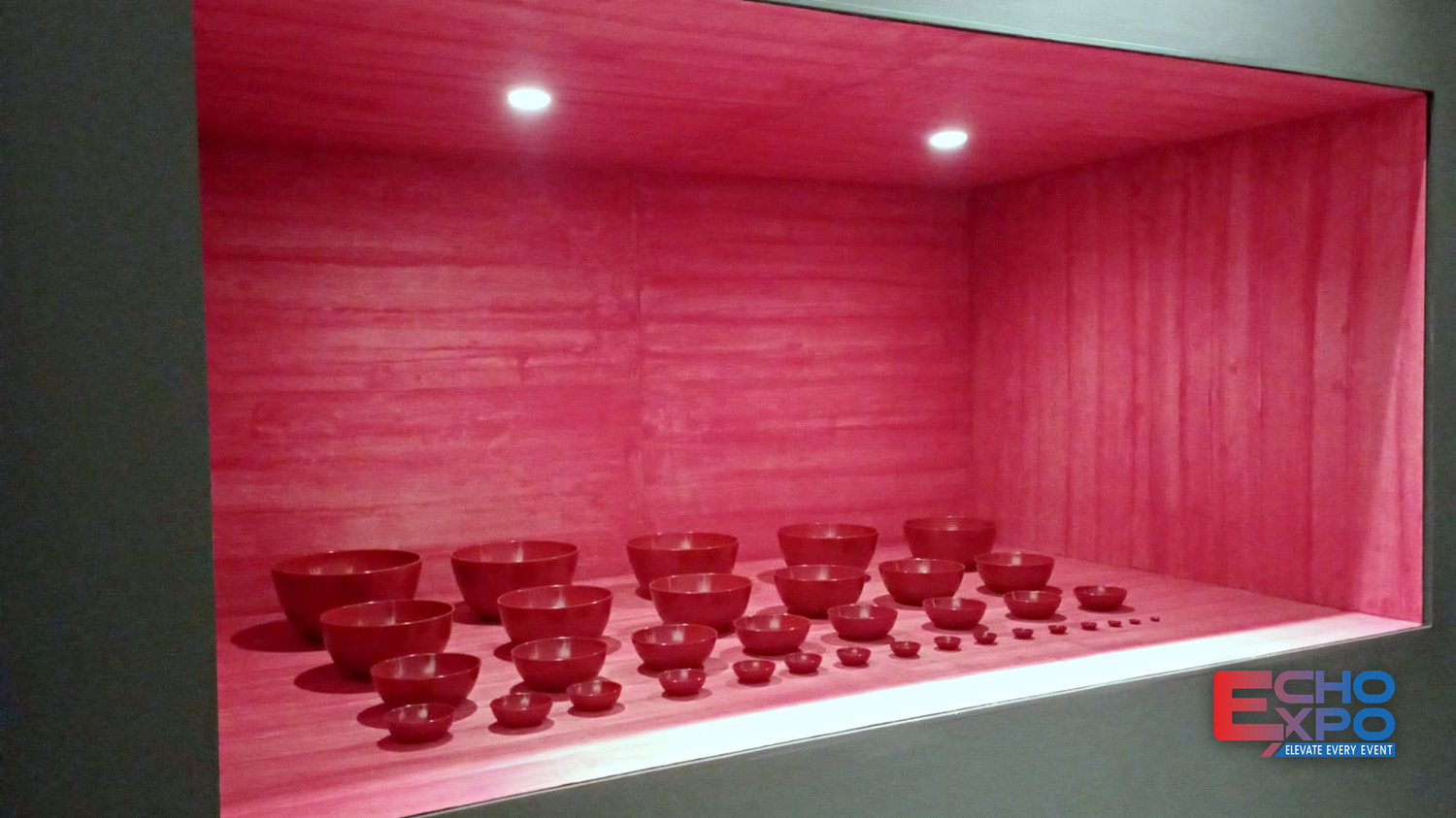 Illuminated recessed display case holding a grid of ceramic bowls at the KCDF exhibition, Rossana Orlandi Gallery, Milan 2024.