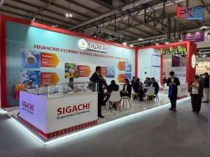 Finished Sigachi Industries stand at CPHI Milan 2026, with its graphic wall, glass display counter and visitors in Hall 1.