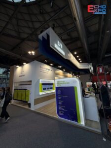 Finished Symbiotec stand at CPHI Milan 2026, with lit product panels and the blue curved fascia in Hall 5.