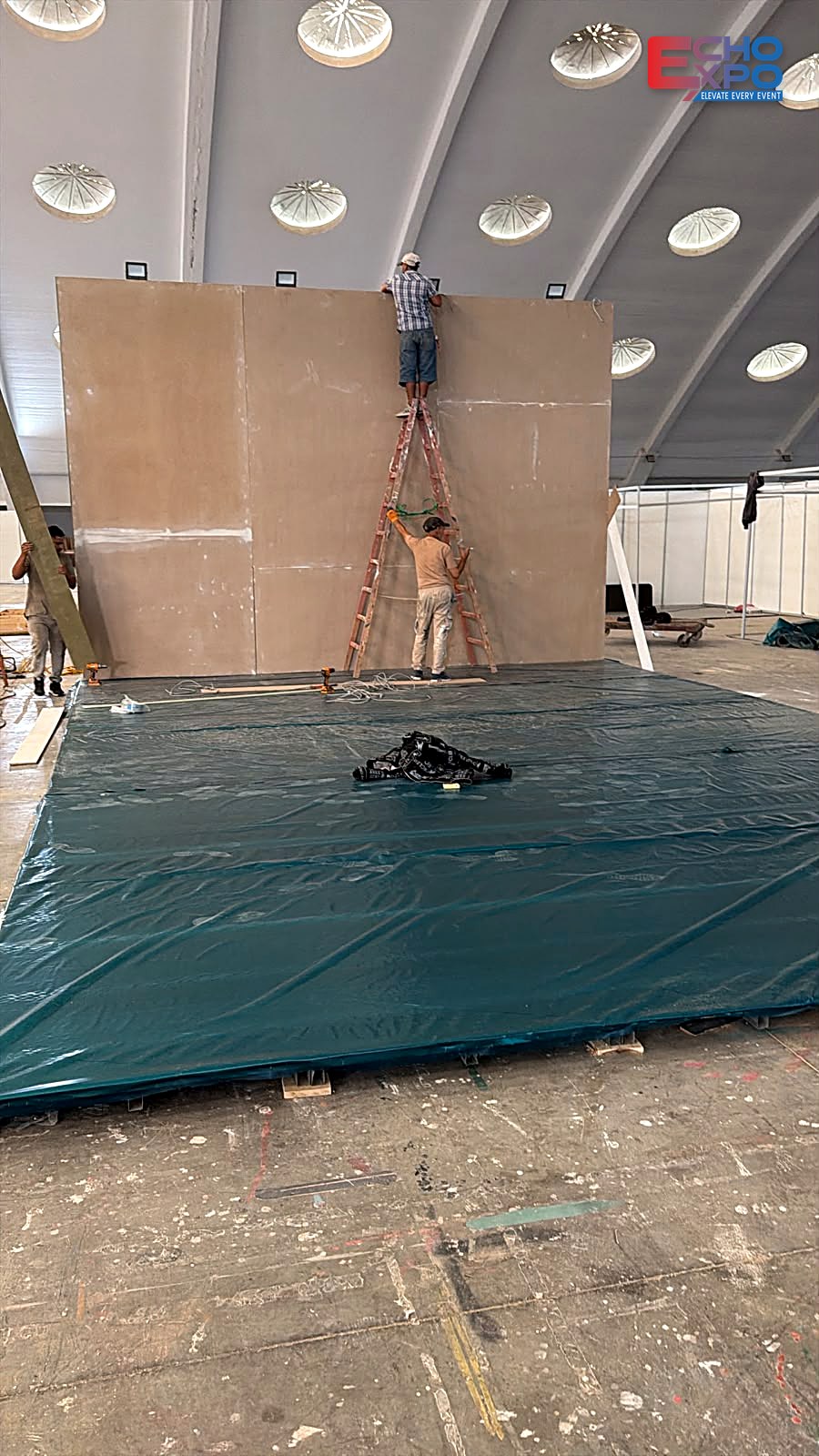 Echo Expo crew raising a prefabricated timber back wall on the protected floor at OFEC Casablanca, EVS Mobility Expo Morocco 2026 build-up.