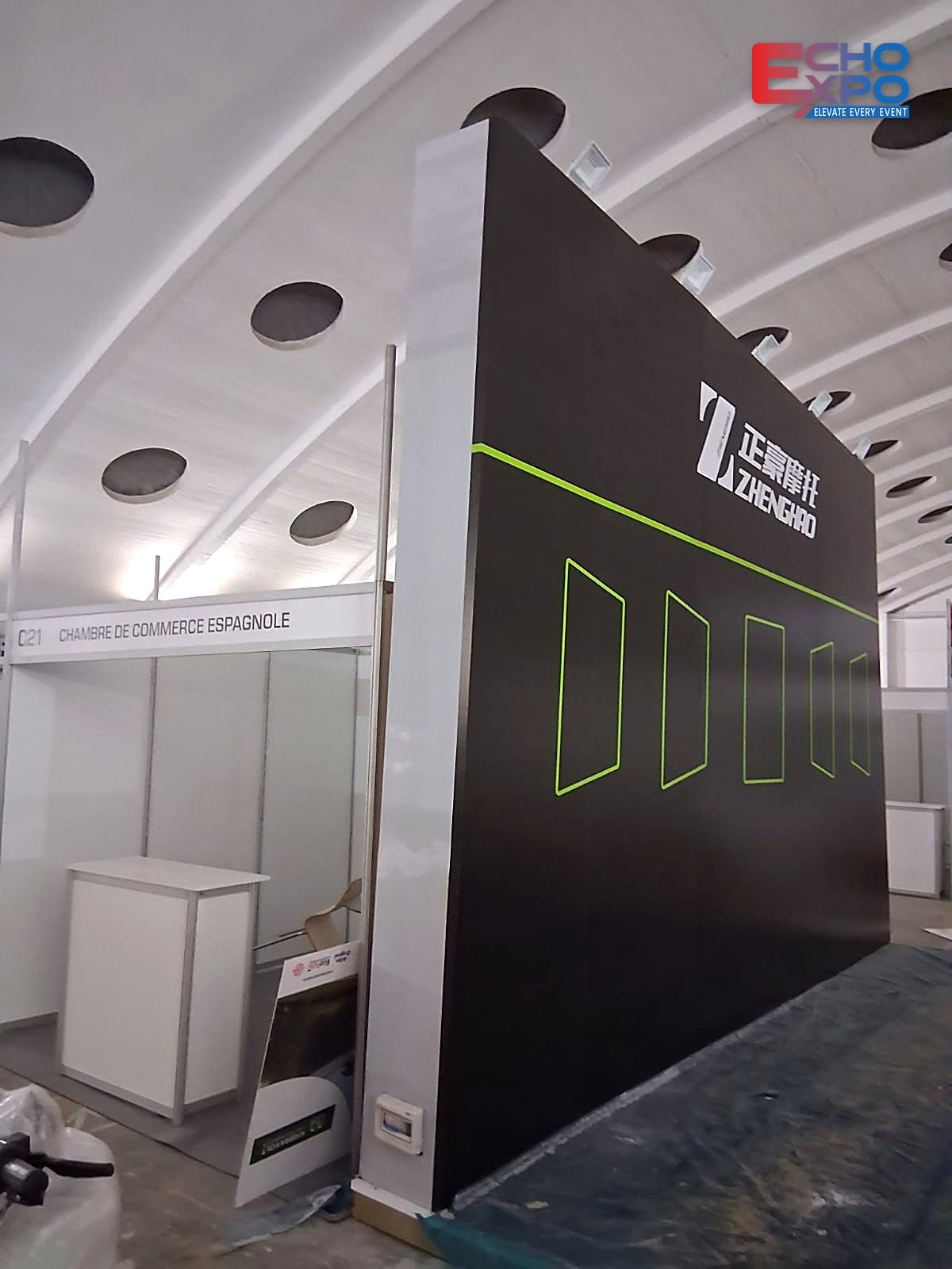 ZHENGHAO black back wall with lime-green line graphics and logo standing during build-up at EVS Mobility Expo Morocco 2026.
